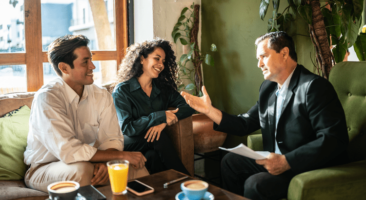 Real estate agent meeting with a couple in a cozy living room to plan a fall home sale