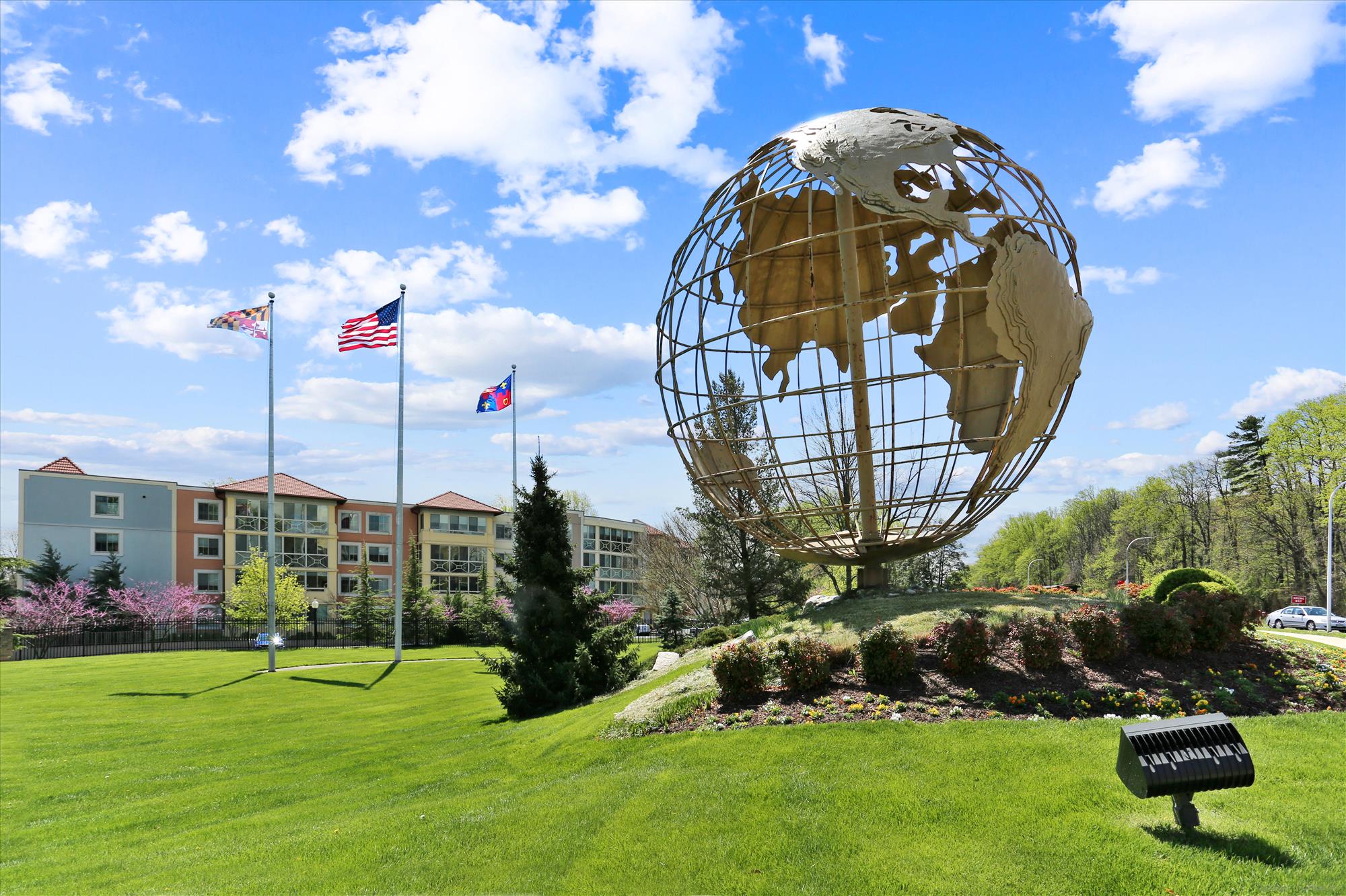 Globe sculpture and flags at the entrance of Leisure World of Maryland in Silver Spring