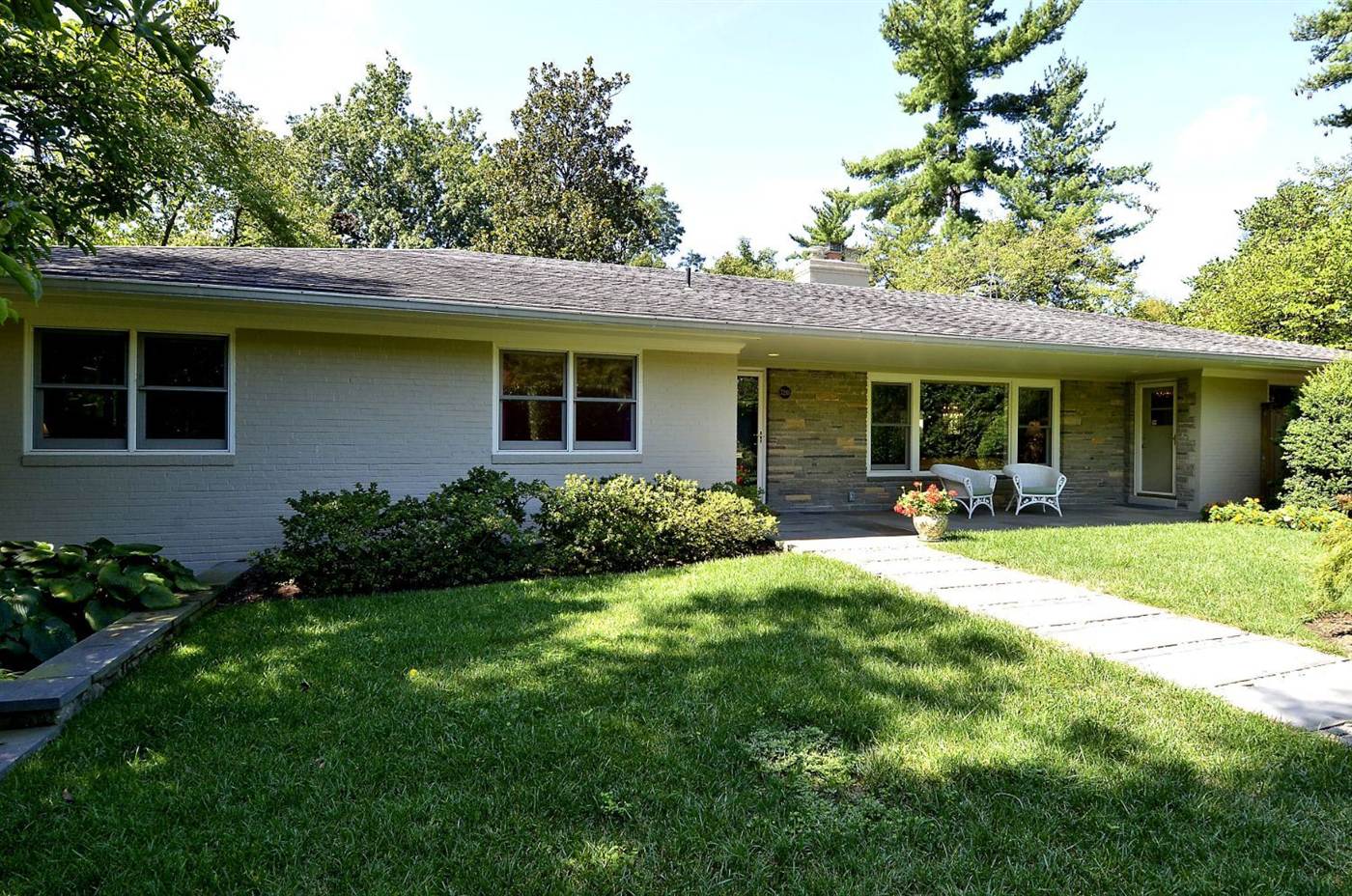 Stone and siding ranch home with a bluestone walk