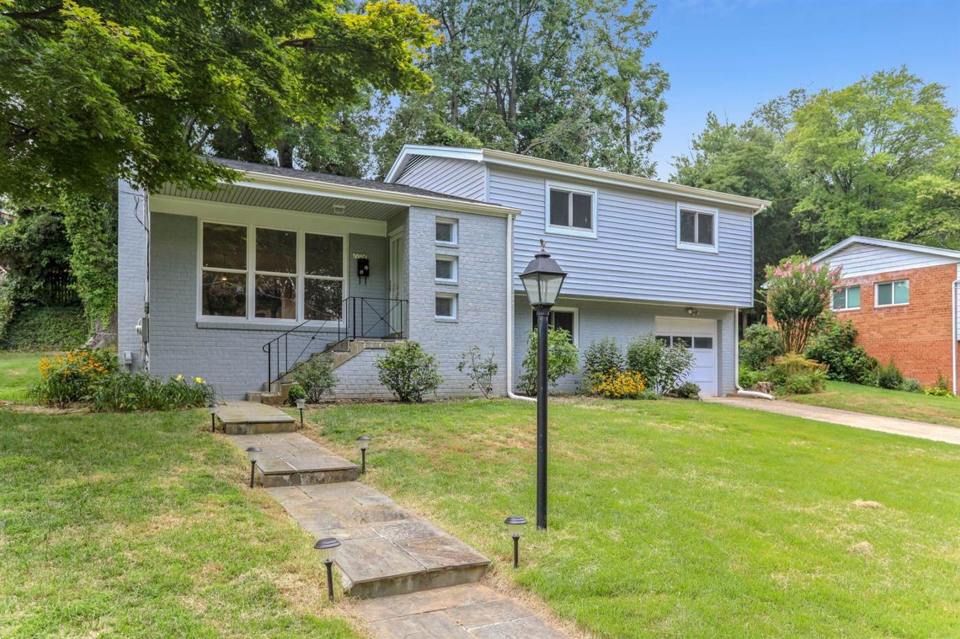 Blue split-level home with a lantern post