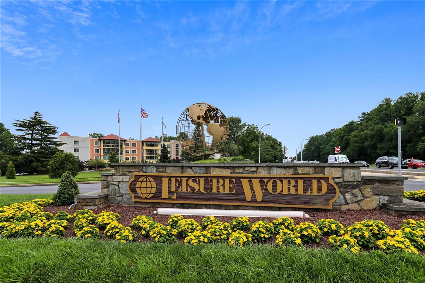 Leisure World of Maryland entrance sign with flower beds and the community globe in Silver Spring