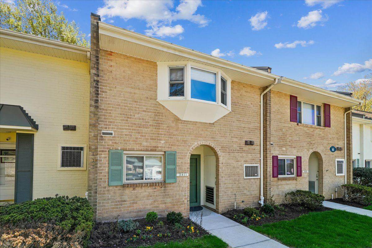 Brick townhouse-style home in Leisure World with a green door