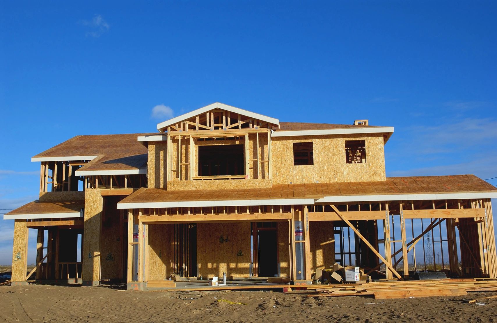 New home under construction in Montgomery County, Maryland, with wood framing and sheathing against a blue sky